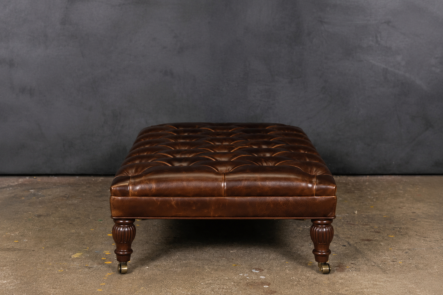 PERCY LEATHER CASTER TUFTED OTTOMAN
